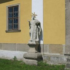 Socha světce vlevo u jižního portálu kostela Nanebevzetí v Chlumu u Třeboně