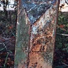 Milepost, N of Mudds Drove, opp. house with wrought iron gates