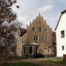 Herrenhaus (Nr. 2) und zwei Wirtschaftsgebäude (Nr. 1 und Nr. 3) eines ehemaligen Gutes, mit zwei Toranlagen (zur Straße und zum Park), Einfriedung zur Straße sowie Hofpflasterung, Vorgarten und Gutspark Am Park 1; 2; 3