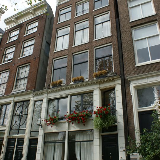 Pand met gevel onder gesneden rechte lijst met triglyfen en consoles, met geblokte pui en omlopende puilijst