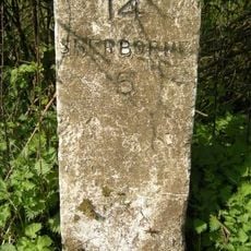 Milestone, entrance to Dunn's Farm 150m S of church.