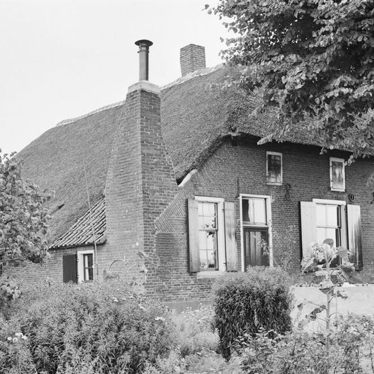 Boerderij onder rieten wolfdak met in de voorgevel jaartalankers