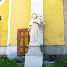Socha světce vlevo u severního portálu kostela Nanebevzetí v Chlumu u Třeboně