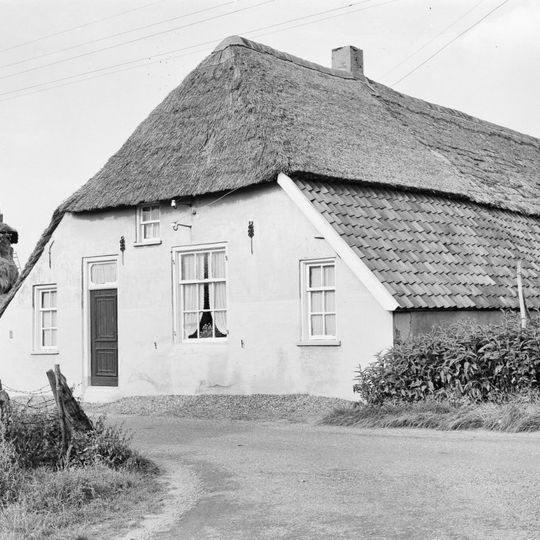 Boerderij met door riet en pannen gedekt wolfdak