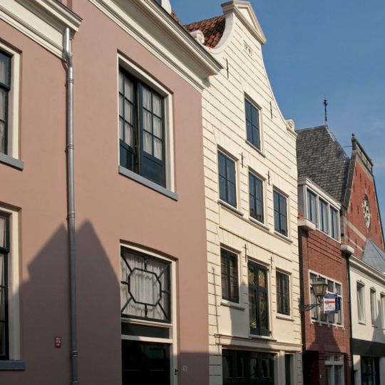 Pand met door driehoekig fronton bekroonde gepleisterde klokgevel en jongere onderpui