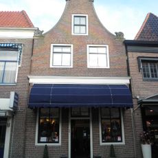 Huis met gepleisterde ingezwenkte halsgevel