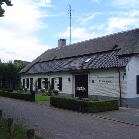 Boerderij van het noordbrabants langgeveltype, tot bungalow ingericht, waartoe het woonhuis tot een groot vertrek is uitgebroken, met behoud van de balklagen en gesneden sleutelstukken