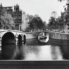 Hoekhuis met halsgevel en een deurpartij in omlijsting en met gebeeldhouwde trapvensters in- en een stoephek tegen de zijgevel