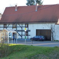 Teil eines Wohnstallhauses und Brunnen mit Handschwengelpumpe Pegenauer Straße 2