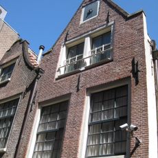 Huis met gevel onder klokvormige top met rollagen