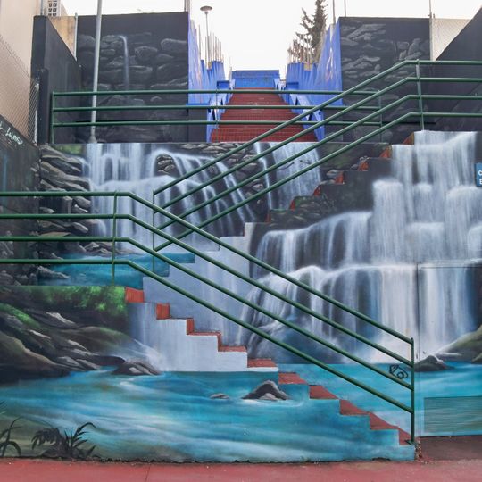Mural que simula una cascada de agua cayendo por unas escaleras.