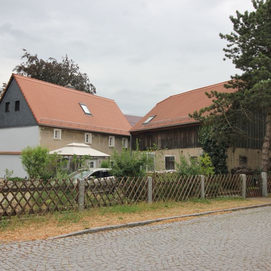 Wohnhaus und Seitengebäude eines Zweiseithofes mit Hofpflasterung Dorfplatz 10