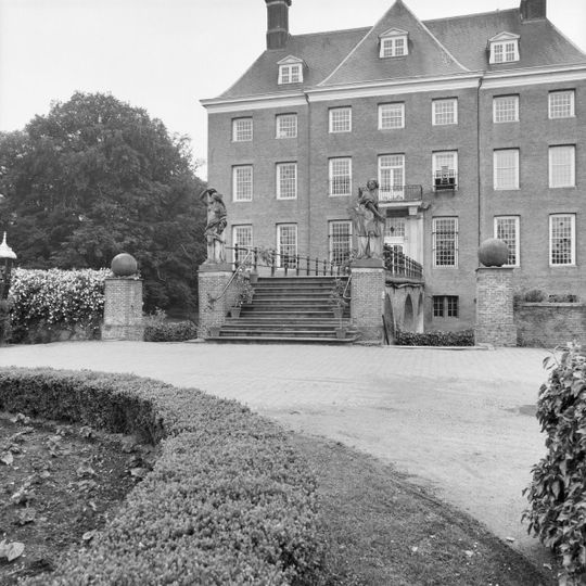 Muren en trappen met beelden en bollen van het voorplein