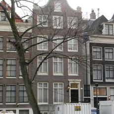 Pand met klokgevel met deur en snijraam hek in gesneden omlijsting