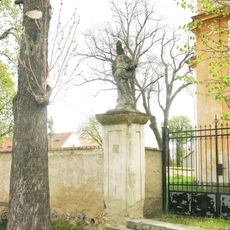 Socha svatého Prokopa u brány k areálu kostela v Břežanech