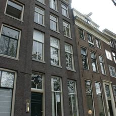 Pand met gevel onder rijk gesneden lijst met consoles en met een gebeeldhouwde cordonlijst