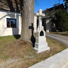 Kříž v severní části návsi v Ústi