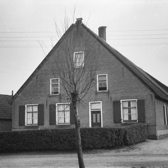 Boerderij onder hoog, rieten zadeldak en aan de voorzijde ijsselstenen puntgevel met rode vensterstrekken