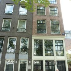 Pand, bestaande uit een hoger opgetrokken voorgedeelte aan de Amstel en een langwerpig achterhuis langs de Bakkerstraat, waarin een eigen toegangsdeur met stoep