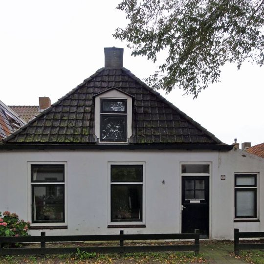 Pand met zesruitsvensters en houten goot op blokjes onder aan de voorzijde afgewolfd zadeldak