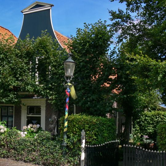 Pand zonder verdieping, onder pannen zadeldak met houten klokgevel aan de voorzijde en voorschot met makelaar aan de achterzijde