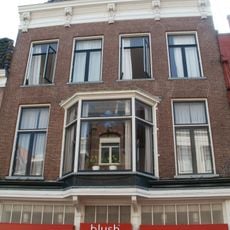 Pand met twee hoge verdiepingen en rechte kroonlijst waarop vijf rijk gesneden consoles