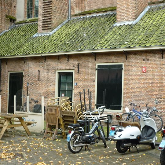 Laag pakhuisje gelegen tegen de noordoostzijde der St.Joriskerk. Voormalige Diakoniewoning
