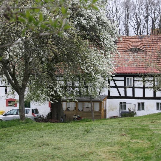 Wohnstallhaus mit angebautem Backhaus, Scheune, Seitengebäude und Einfriedungsmauer eines Bauernhofes An der Hohle 5