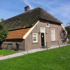Boerderij met wolfdak, gedekt door pannen en riet