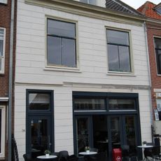 Huis met zadeldak waarin dakvenster met vleugelstukken en gepleisterde lijstgevel