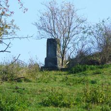 Podstavec ulomeného kříže na pastvině v severní části Veselého