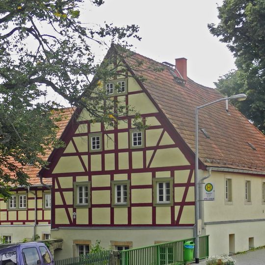 Wohnstallhaus, winkelförmig angebautes Seitengebäude und Scheune eines Bauernhofes Pirnaer Straße 38
