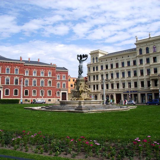 Postplatz; Muschel-Minna Schmuckplatz mit Brunnen und Brunnenaufsatz sowie zwei Solitärbäumen Postplatz