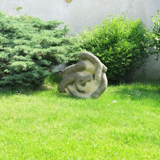 Kamenná plastika Gordický uzel na křižovatce u vjezdu do Radonic