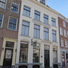 Pand onder hoog schilddak, waarin dakkapel met segmentvormig fronton, vleugelstukken en hijsbalk