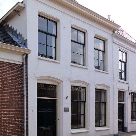 Onderkelderd pand met verdieping en gepleisterde voorgevel onder schilddak