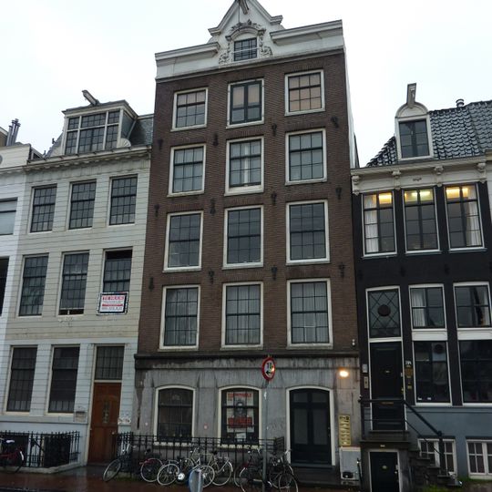 Pand met forse gevel onder gewijzigde lijst, in het midden onderbroken door het door snijwerk omgeven vlieringluik