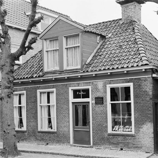 Pand zonder verdieping onder schilddak met hoekschoorstenen waarvan een met versierd bord