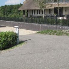 Hek met twee hardstenen pijlers met koppen