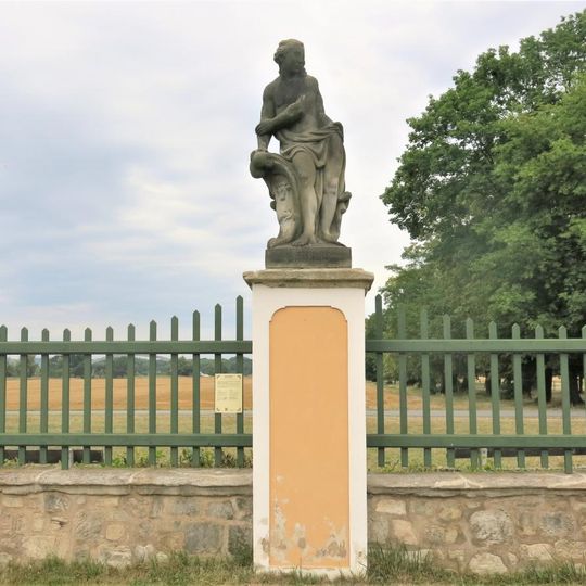 Alegorická socha Duben v ohradě zámecké zahrady ve Veltrusech