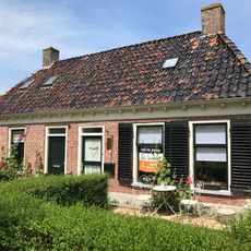 Pand met goot op klossen onder schilddak met hoekschoorstenen (vormt een geheel met nr. 13)