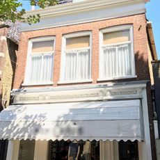 Pand met rechte kroonlijst onder zadeldak met voorschild met schoorsteen