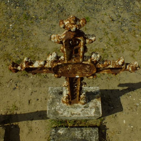 Gietijzeren grafkruis op hardstenen sokkel