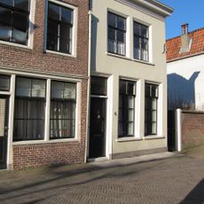 Pand, met aan de achterzijde een puntgevel en in de voorgevel, schuiframen met gegroefde middenstijlen