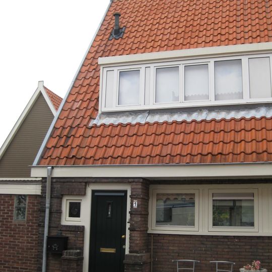 Blok met 8 keukenwoningen, zo genoemd vanwege destijds nieuwe plaatsing van keuken aan de voorzijde, aan de zijkant een houten topgevel, bouwstijl Amsterdamse School.