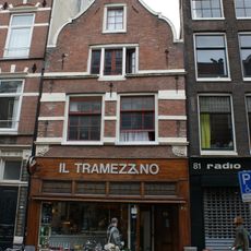 Pand met gevel van het 'type met grote blokken' met uit- en ingezwenkte hals met palmet in de afdekking