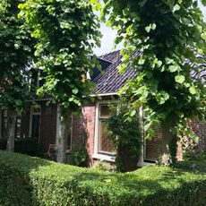 Dubbel pand met goot op klossen onder schilddak (vormt een geheel met nr. 17)