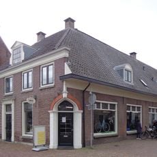 Pand met lage gevel met rechte kroonlijst, deels verbouwd