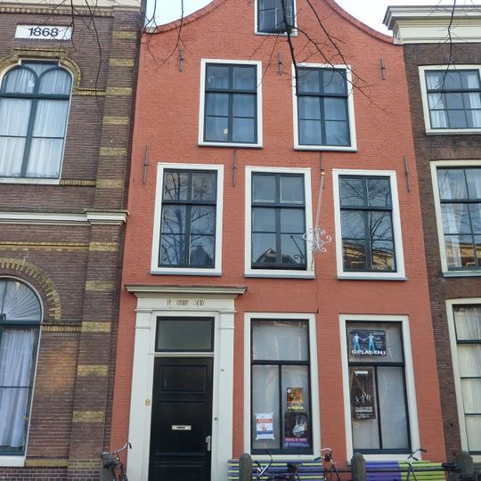 Pand met tuitgevel. Hardstenen stoep, onderpui 18e eeuw vernieuwd. Deuromlijsting