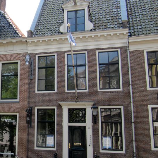 Vier traveeën breed onderkelderd hoekpand met verdieping onder zadeldak tegen puntgevel